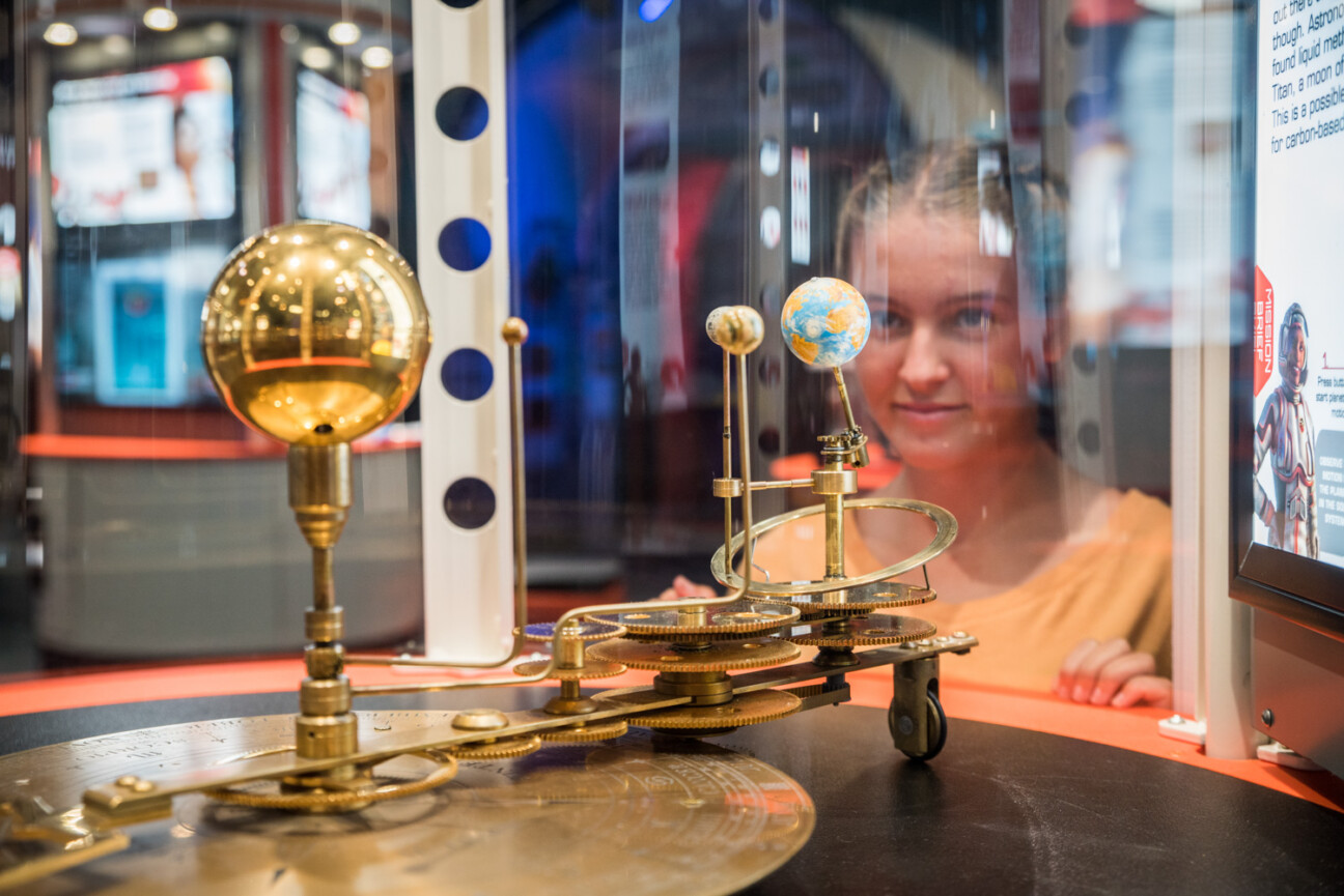 Child looking at an exhibit of the solar system