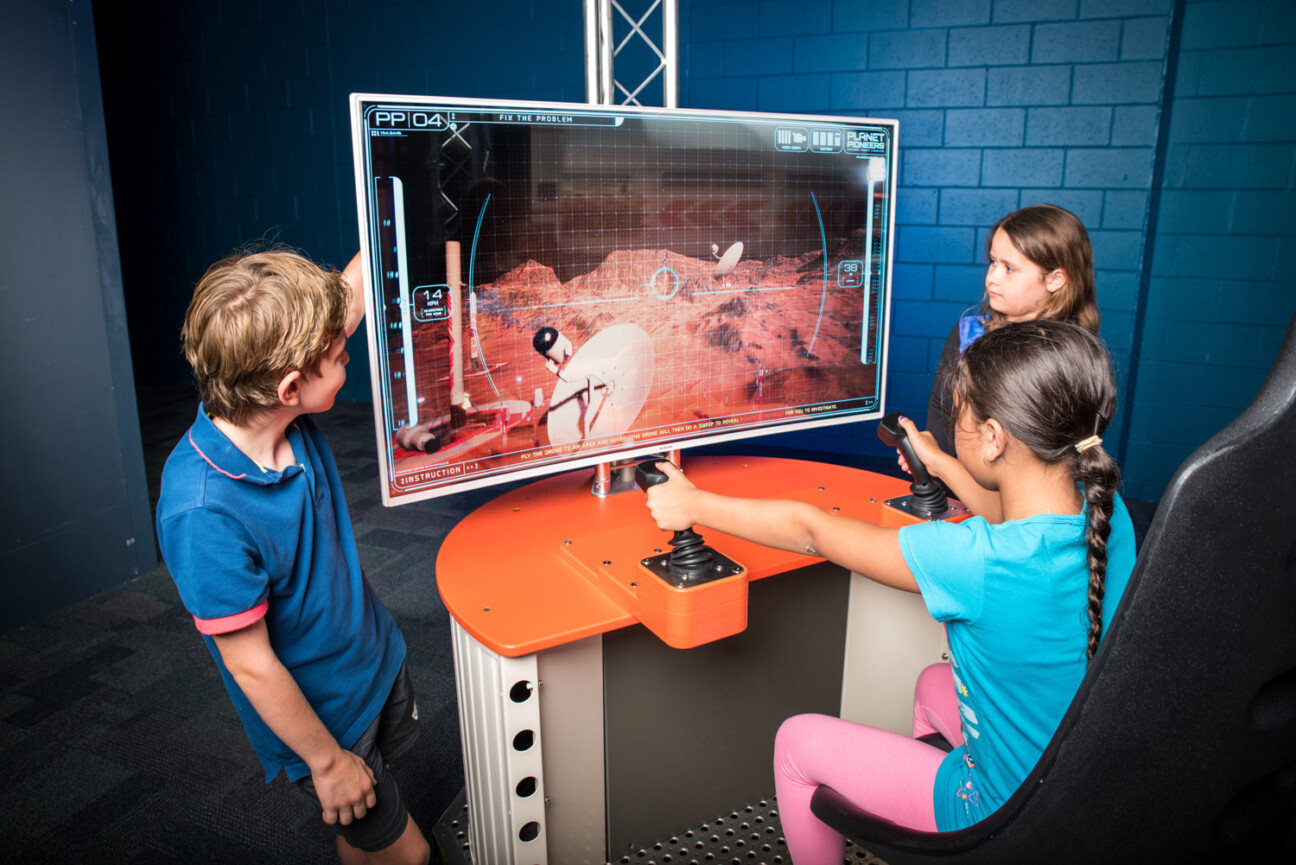 Three children controlling a virtual drone in the Destination Mars exhibition