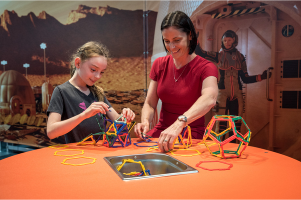 Adult and child building using magnet shapes.